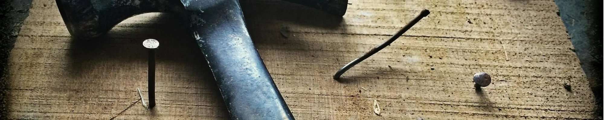 hammer and nails on wooden table from American Flooring in Lansing-East Lansing, MI